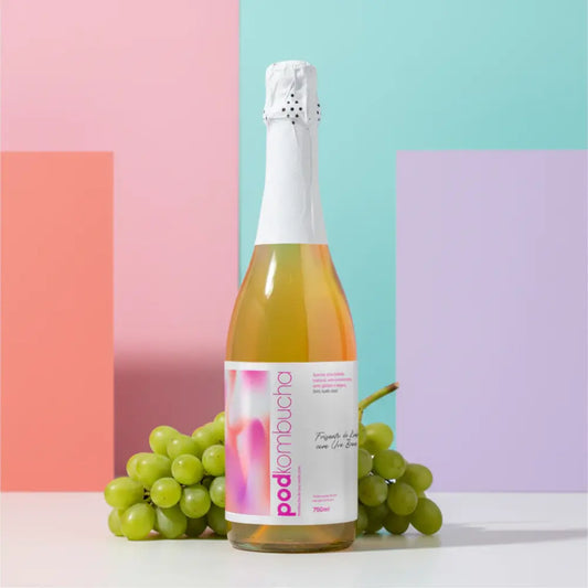 espumante kombucha sem alcool de uva pod, com uvas atras da garrafa