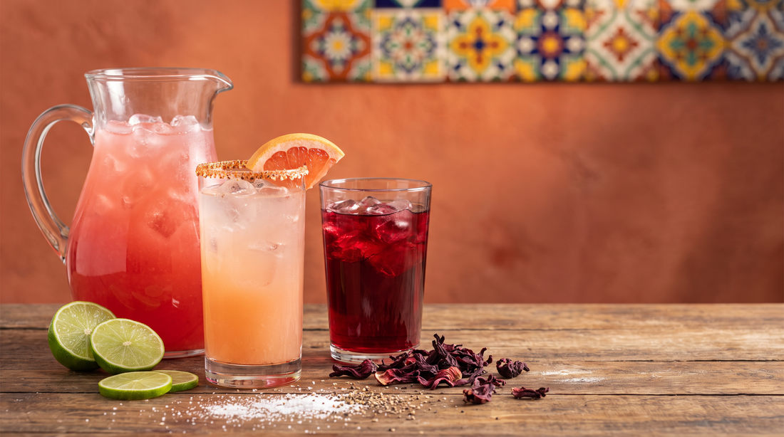 Bebidas mexicanas sem álcool: agua fresca de melancia, paloma de toranja e chá de jamaica em mesa de festa