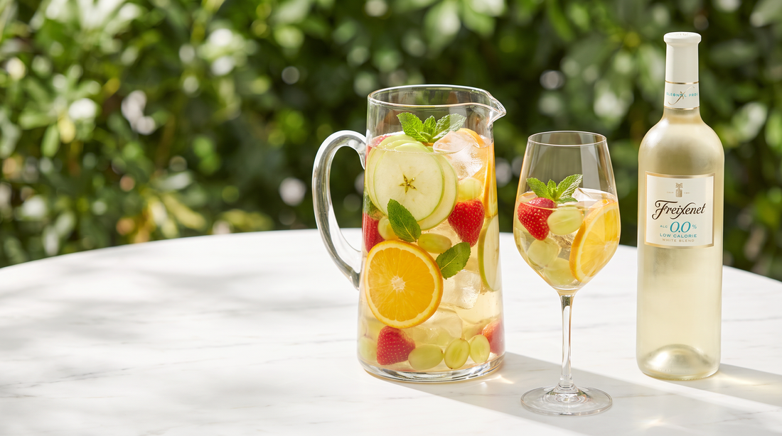 Clericot sem álcool numa jarra com frutas frescas e garrafa de vinho branco 0,0% em mesa de verão